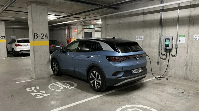 Elektroauto lädt an Wallbox am Reihenhaus in der Morgensonne